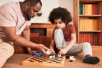 Отец и сын играют в шашки