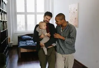 Papás sosteniendo a su bebé y hablando estrechamente con él.