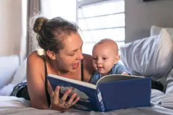 Mamă care citește carte cu bebeluș