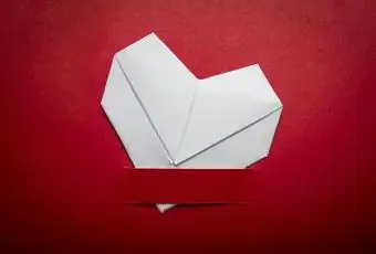 coração dobrado em origami em fundo vermelho