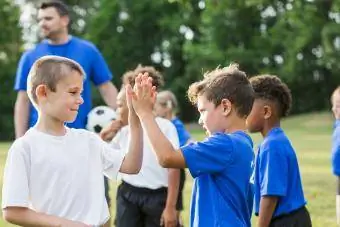 jó sportszerűséget mutató gyerekek a futballtáborban