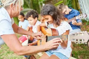 Csoport gyerekek gitároznak a szabadban