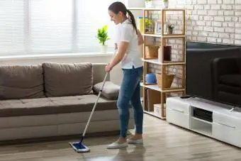 donna pulisce il pavimento con un detergente per pavimenti in laminato fatto in casa