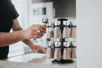 Lalaking nag-aabot ng spice mula sa spice rack