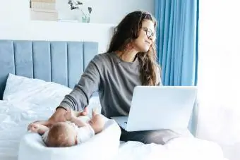 Anne evde ve bebeği dizüstü bilgisayarda yazıyor