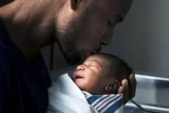 Baba yeni doğan oğlunun alnını öpüyor
