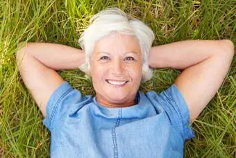 Senior donna sdraiata sull'erba rilassante