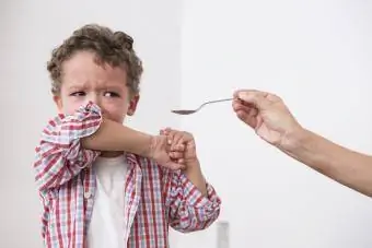 bambino che piange e rifiuta le medicine