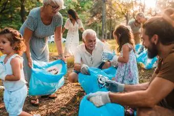 Счастливая семья из нескольких поколений занимается волонтерством и собирает мусор
