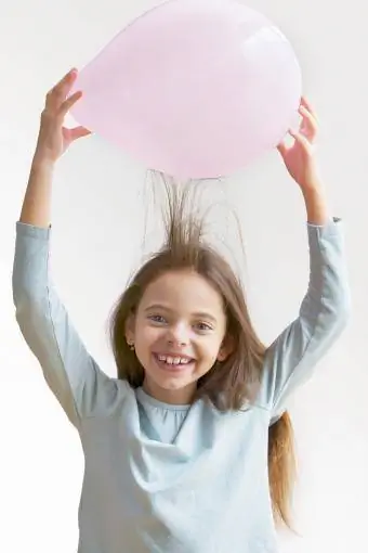 Meitene rada statiskus matos ar balonu