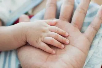 Die Hand von Vater und Baby