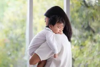Μητέρα που αγκαλιάζει το κοριτσάκι της ενώ κοιμάται
