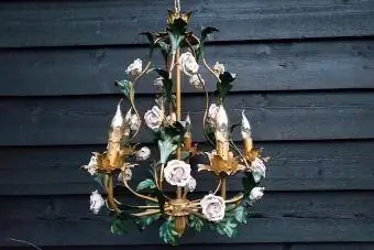 Włoski żyrandol w kolorze złotym z różowymi porcelanowymi różami i zielonymi liśćmi