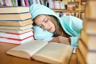 Kitaplarla uyuyan öğrenci