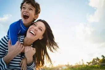 Femme avec fils jouant à la plage