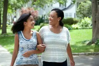 Mãe e filha caminhando juntas na vizinhança