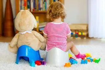 ragazza sul vasino accanto all'orso imbottito sul vasino