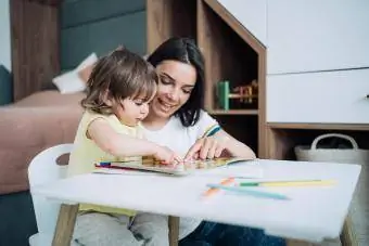 Babá e menina desenhando juntas