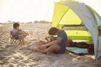 समुद्र तट पर तम्बू के साथ लड़का