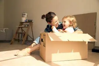 Femme et fille assises dans des cartons de déménagement