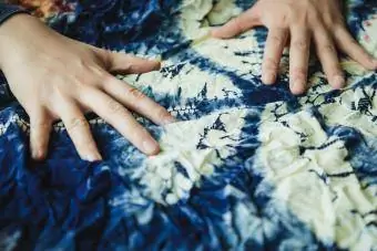 mains touchant le tissu shibori