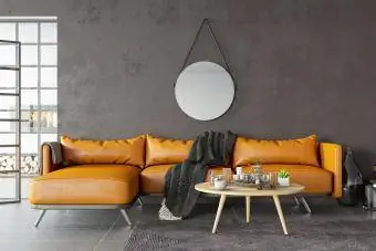 skórzana sofa w kolorze wielbłądziej na tle ściany w kolorze espresso