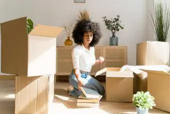 Женщина распаковывает вещи в своей новой квартире