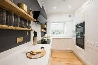 witte ingerichte keuken in shaker-stijl met geborstelde messing gouden handgrepen