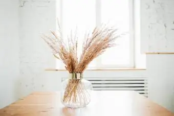 Суха трева в декорация на стъклена ваза