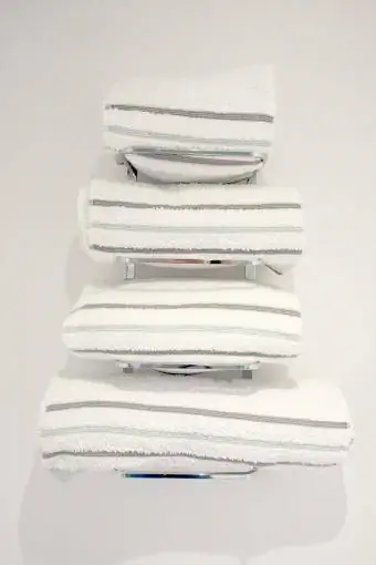 Krom handdukshängare som håller handdukar i ett badrum
