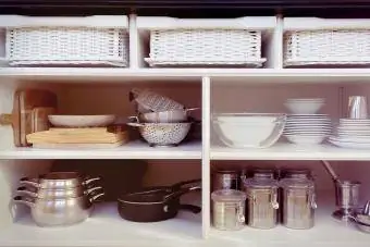 Контейнери и керамика, подредени в рафтове в кухнята