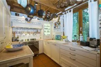 آشپزخانه به سبک کانتی با قابلمه و تابه بسیار بالا آویزان شده است