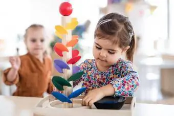 Twee kleutermeisjes die met knikker spelen, rennen binnenshuis in de kinderkamer