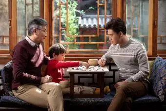 Ķīniešu ģimene spēlē go spēli