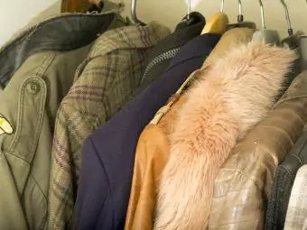 Вид дорогих мужских курток, висящих в шкафу для одежды