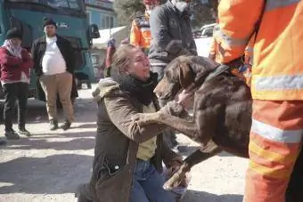 Uma mulher segura seu cachorro após o terremoto na Turquia