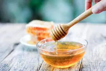 Gayung madu dan sarang lebah di atas meja