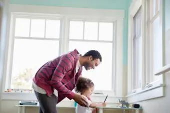 Ojciec pomaga córce w odrabianiu zadań domowych