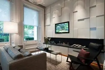 Area salotto con schermo al plasma e fuoco incassato in un appartamento nella città di Londra