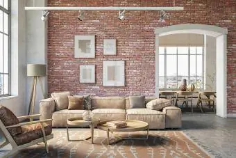 Interno soggiorno bohémien con muro di mattoni