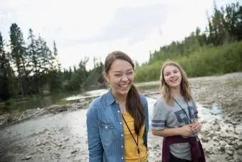 Kaksi teinityttöä nauraa vaeltaessaan