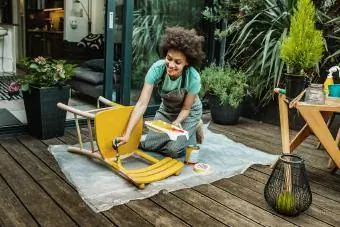 La femme colore une chaise à la maison