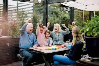 Familie veselă care joacă un joc de masă