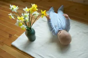 Bebè amb gerro de narcisos barrejats