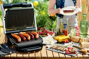 Schreibtisch mit Elektrogrill und Grillwürstchen