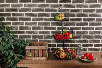 Fruktkorg i loft stil kök med vintage tegelvägg bakgrund