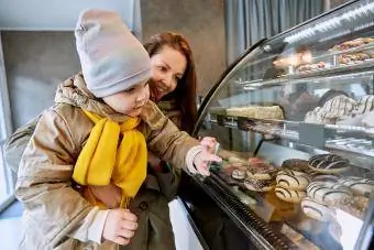 Mor og datter vælger doughnut på en cafe