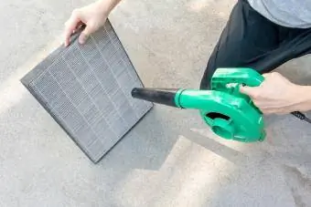 Žena vysáva špinavú čističku vzduchu HEPA filter