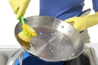 Kobieta myje patelnię ze stali nierdzewnej