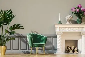 Ruang tamu dengan kursi tunggal, tanaman pot, panel dinding, dan perapian